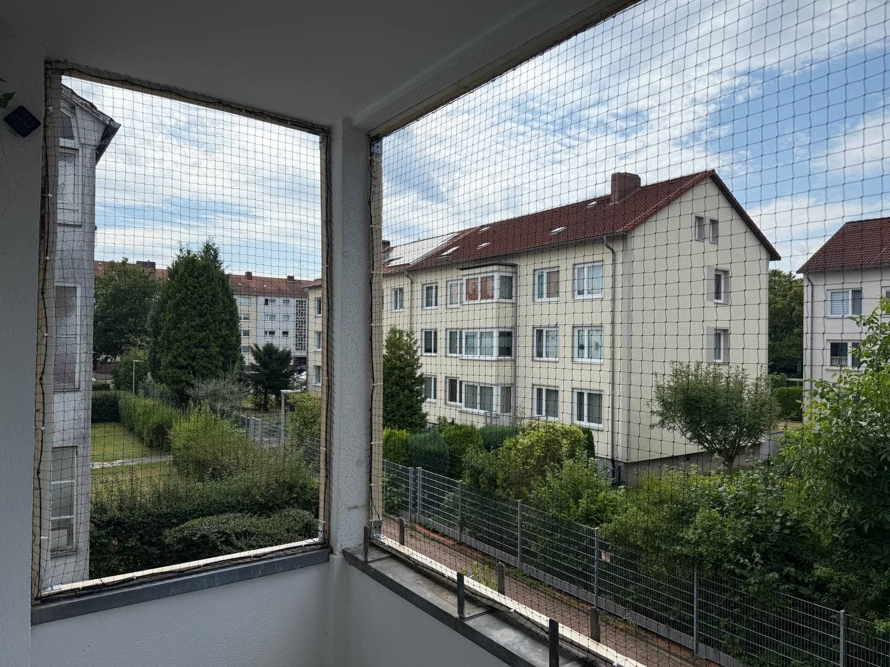 Schutznetz gegen Tauben und für Katzen über den offenen Seiten eines Balkons, Blick von innen