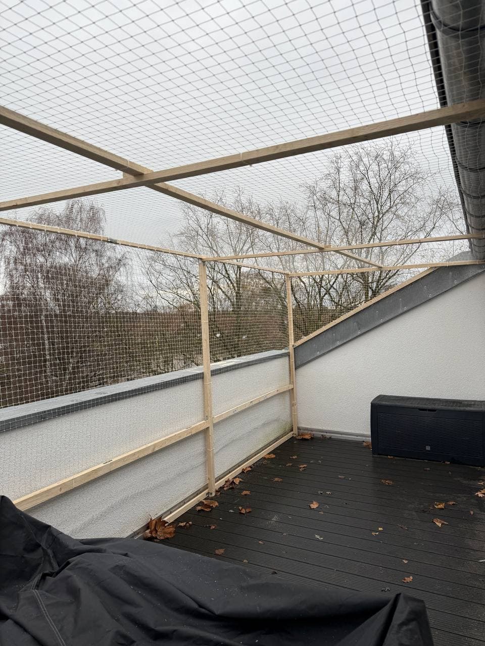 Katzenschutznetz an den Seiten und über einer Dachterrasse, gespannt auf einen Rahmen aus Holzlatten